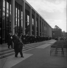 Photograph of a convocation procession in front of the Tupper Building