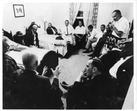 Photograph of a meeting taking place in a bedroom in Africville