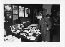 Photograph of an unidentified person looking at a display about graphics and typesetting