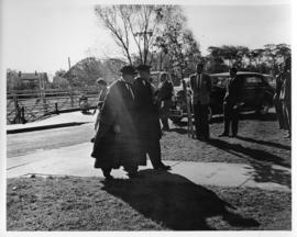 Photograph of two unidentified people in robes walking outside