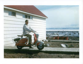Photograph of Barbara Hinds sitting on a red scooter in Frobisher Bay, Northwest Territories