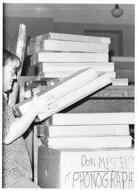 Photograph of Mary Ellen Wright packing the Don Messer collection