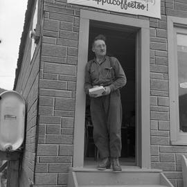 Photograph of an unidentified man standing in a doorway in Dawson City, Yukon