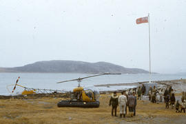 Photograph of several people standing by a helicopter in Cape Dorset, Northwest Territories