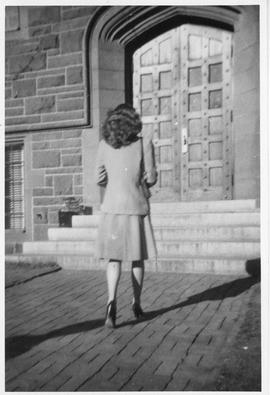 Photograph of an unidentified person walking toward a door