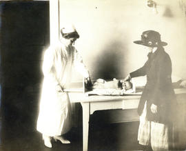 Photograph of Health Centre No. 1 nurse measuring baby