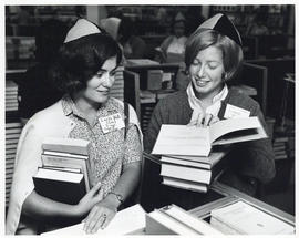 Photograph of two women looking at books