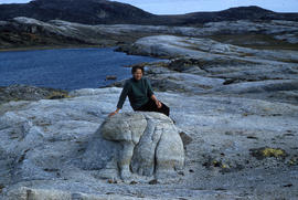 Photograph of Rosemary Gilliat sitting on a rock in Cape Dorset, Northwest Territories