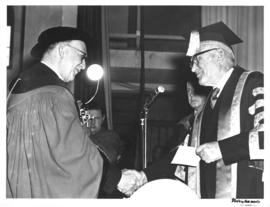 Photograph of two men shaking hands at the opening ceremony of the Sir James Dunn Building