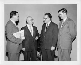 Photograph of four unidentified people talking