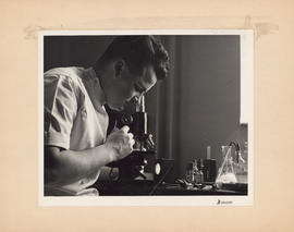 Photograph of doctor looking into microscope at the Outpatient and Public Health Clinic