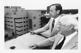 Photograph of Henry Hicks and an unidentified person standing on the roof of the Henry Hicks Acad...