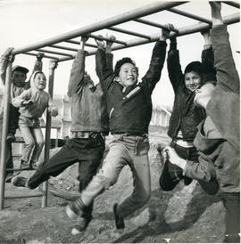 Photograph of six children playing on monkey bars in Fort Chimo, Quebec