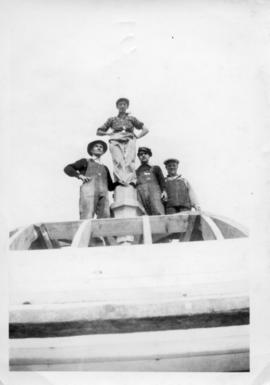 Photograph of four men standing on top of the Arts & Administration Building
