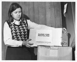 Photograph of Anna Oxley holding a box of paper for recylcling