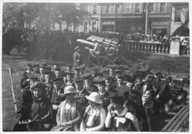 Photograph of a group of people in academic dress sitting in chairs on the Grand Parade