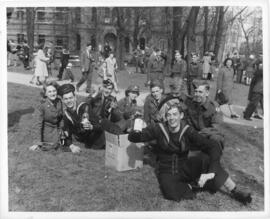 Photograph of servicemen and women celebrating VE-Day with looted beer in a Halifax park
