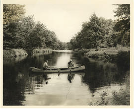 Photograph of two men netting a caught fish from a canoe on Mersey River at or near Jacques Landi...