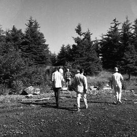 Photograph of a group of people walking on the shore on McNab's Island