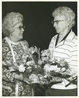 Photograph of Mrs. J. R. Longard presenting a floral arrangement to Mrs. F. R. MacAloney