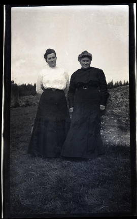 Two women leaning on a rock