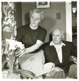 Photograph of Thomas Head Raddall watching his wife Edith arrange daffodils