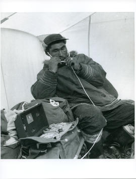 Photograph of an unidentified man with a tape recorder and headphones