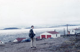 Photograph of Barbara Hinds walking toward some houses in Frobisher Bay, Northwest Territories