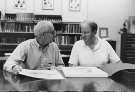 Photograph of Bill Birdsall, University Librarian, and an unidentified man looking at prints in t...