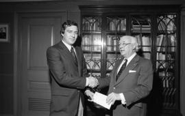 Photograph of an unidentified person presenting a cheque to Henry Hicks
