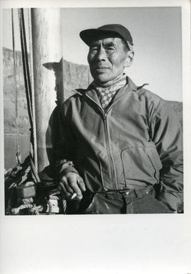 Photograph of Eetuk smoking a cigarette on a boat in Frobisher Bay, Northwest Territories