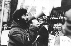 Photograph of Larry Katz, Graduate Student Council President, addressing a crowd in front of the ...