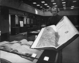 Photograph of Dalhousie archivist with large map book