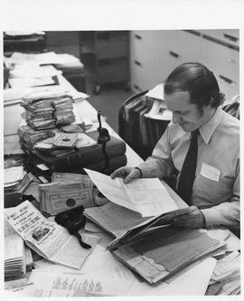 Photograph of Charles Armour looking at historical documents
