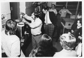 Photograph of Ralph Deveau demonstrating scientific equipment