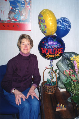 Photograph of Barbara Nielsen with balloons and bouquets at the Killam Memorial Library