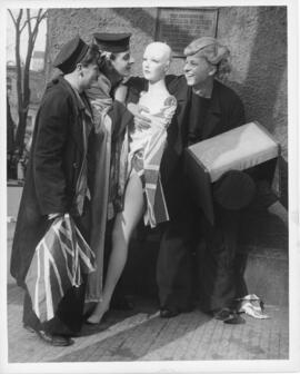 Photograph of two sailors and a woman embracing a looted shop mannequin wrapped in a Union Jack f...