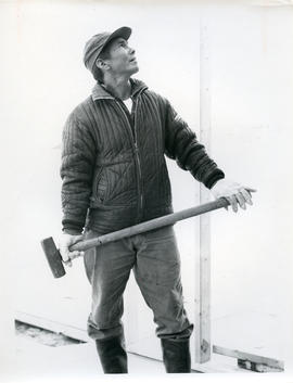 Photograph of a man holding a sledgehammer in Fort Chimo, Quebec