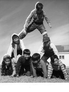 Photograph of children making a human pyramid in Cape Dorset, Northwest Territories