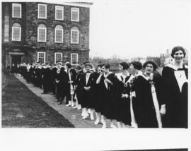 Photograph of graduating students lined up next to yr Science Building
