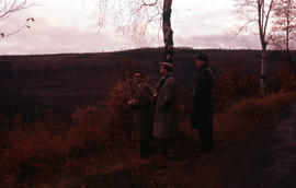 Photograph of three unidentified men near old farms (alte hofe)