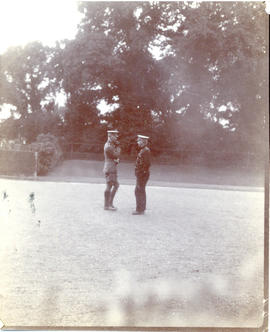 Photograph of two officers in uniform conferring on the lawn at Hythe, England