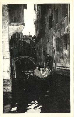 Photograph of Thomas Head and Edith Raddall riding a gondola in Venice, Italy printed on a postcard