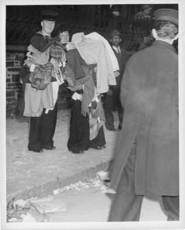Photograph of two sailors carrying armfuls of looted clothes during the Halifax VE-Day riots