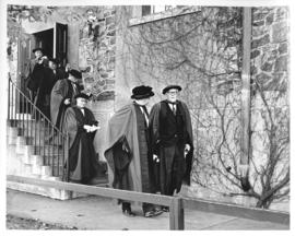 Photograph of unidentified people in robes walking downstairs outside
