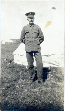 Portrait of T.H. Raddall, Sr. in uniform standing in front of a tent at Valcartier Camp, Quebec