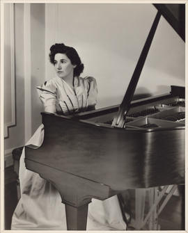Publicity photograph of Ellen Ballon playing a piano