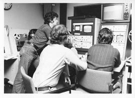 Photograph of three unidentified people operating television equipment
