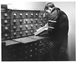 Photograph of a student using the card catalogue in the Macdonald library