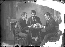 Photograph of 3 individuals playing cards